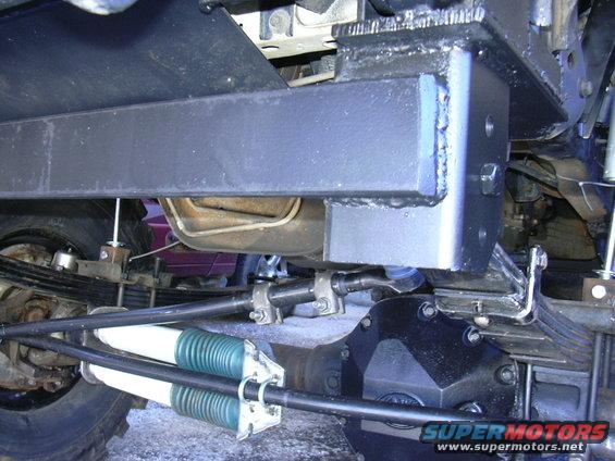 Undercarriage view of a solid axle swap with green and white shocks