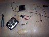 Car headlight assembly with wiring, pliers, and wire cutters on a floor