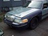 Mercury Grand Marquis with a dented hood and mismatched fender, viewed from the front-right