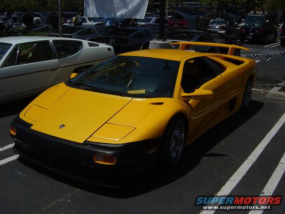 Yellow Lamborghini Diablo parked in a lot, other cars in background
