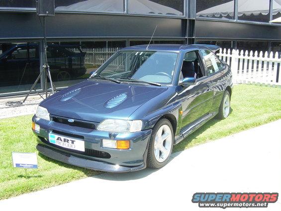 Dark blue 1993 Ford Probe with a rear spoiler and hood vents, parked on grass