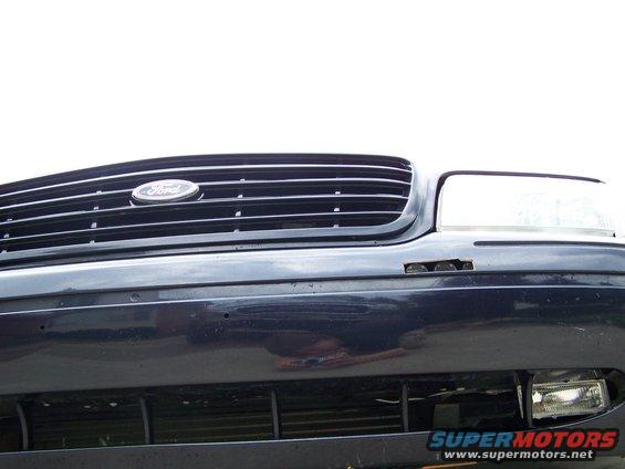 Front of a 2003 Ford Crown Victoria showing the grille and headlight