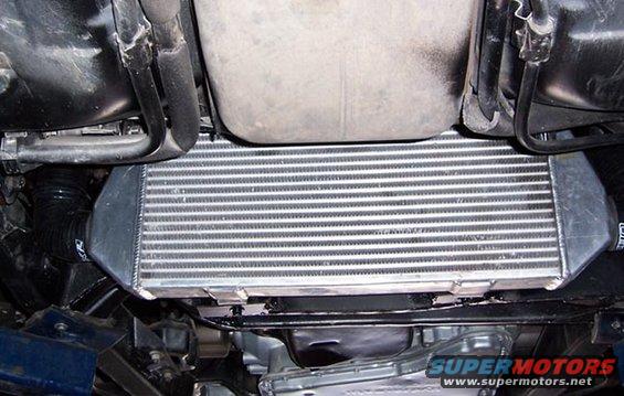 underside view of car's intercooler with hoses and some engine components
