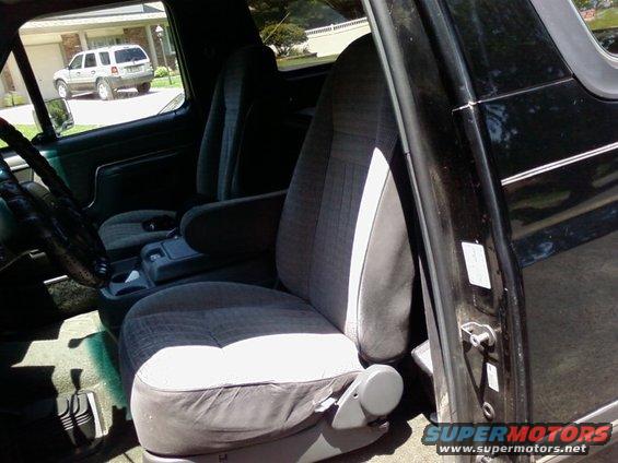 1989 Ford Bronco interior with grey cloth seats, center console, and steering wheel visible; black exterior paint