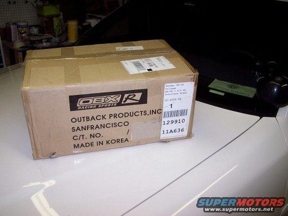 Cardboard box with OBX Racing Sports logo on a white car hood
