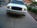 2000 Ford Crown Victoria - The front of a white Ford Crown Victoria is shown parked in a driveway with a second vehicle in the background.