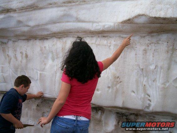 Kids writing on a snow bank/wall on the side of the Pike's Peak road