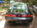 1995 Nissan 240SX - The rear of a black Nissan 240SX is shown with dual exhaust pipes and a Nissan badge.