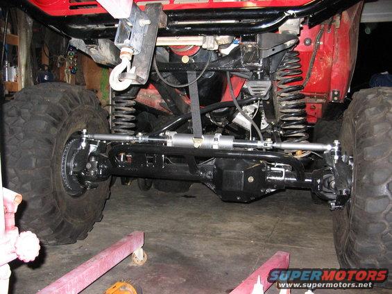 Red off-road vehicle's front suspension and steering components