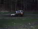 1990 Ford Bronco - A muddy 1990 Ford Bronco navigates a challenging off-road terrain, with its spare tire mounted on the rear.