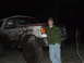 1990 Ford Bronco - Man stands next to a heavily mud-splattered 1990 Ford Bronco in the dark.