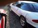 1993 Ford Probe - A white coupe with extensive damage to its side is parked outdoors next to another vehicle.