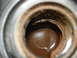 1998 Ford Crown Victoria - Engine oil with sediment visible inside a metal container.