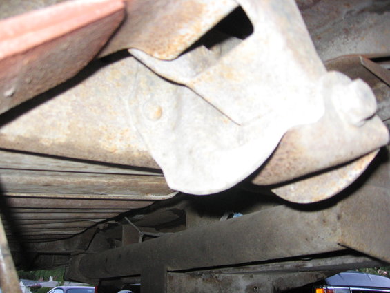 Close-up of rusty undercarriage components and frame rails