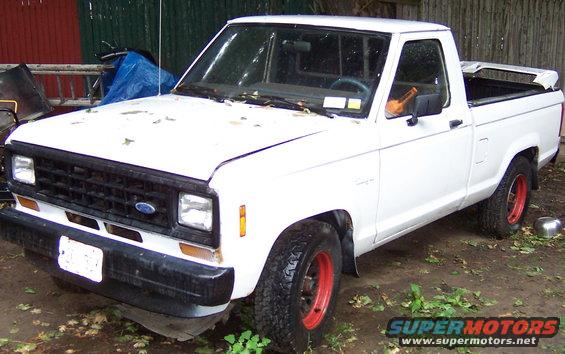White Ford Ranger pickup truck with red rims parked outdoors