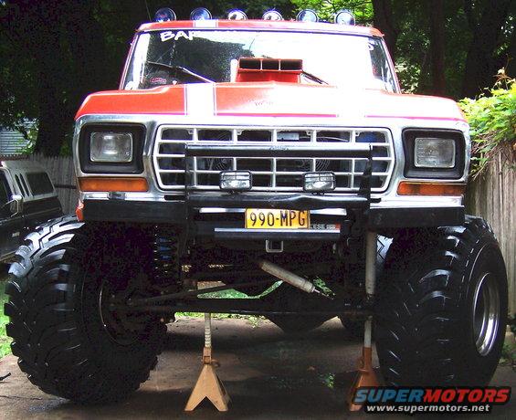 1978 Ford Bronco lifted with massive tires, hood scoop, and auxiliary lights