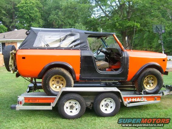 Orange and black International Harvester Scout II on a U-Haul trailer