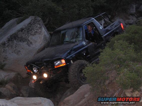 1997 Chevrolet C/K Pickup off-roading over large rocks with a person driving