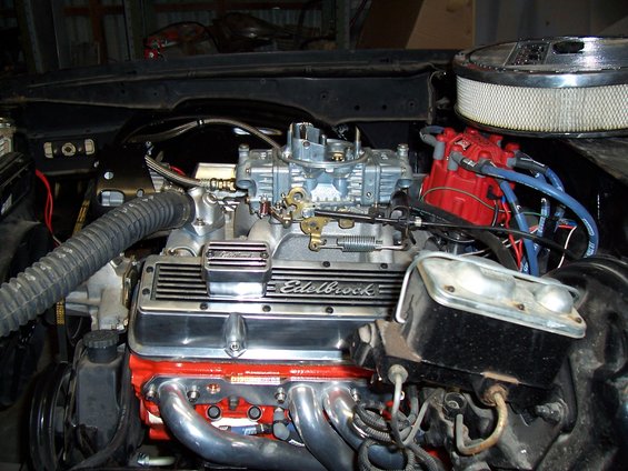 V8 engine with Edelbrock valve covers, carburetor, and red distributor