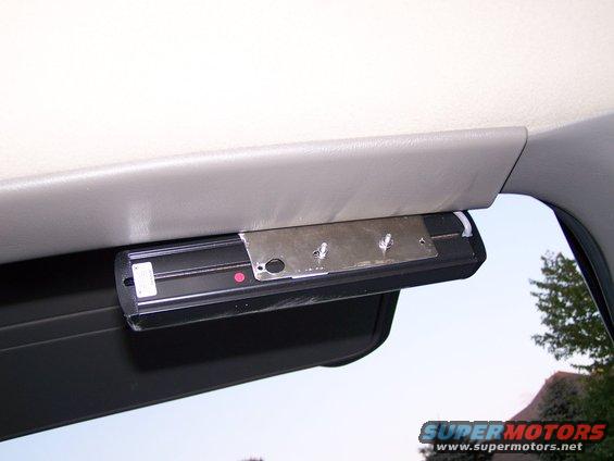 Interior light fixture mounted above a visor, with a metal bracket and visible screws
