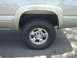 2002 Chevrolet Silverado 2500 - The rear wheel and fender of a Chevrolet Silverado 2500 are visible in this side profile shot.