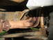1978 Ford Bronco - Undercarriage view of rusted exhaust and suspension parts.
