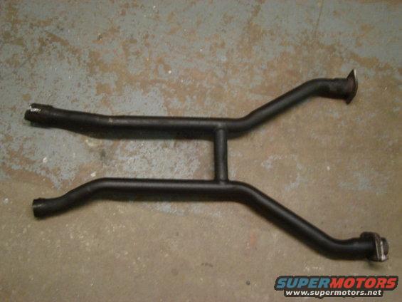 Black dual exhaust pipe assembly on concrete floor