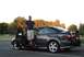 2005 Mazda 6 - Man stands by his 2005 Mazda 6 sedan, showing off the car's profile and spoiler.
