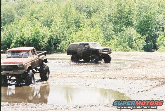 Lifted Ford pickup truck and lifted Chevrolet K5 Blazer driving through mud