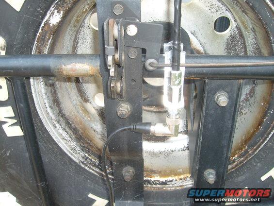 CB antenna mount attached to spare tire carrier, showing bracket and cable