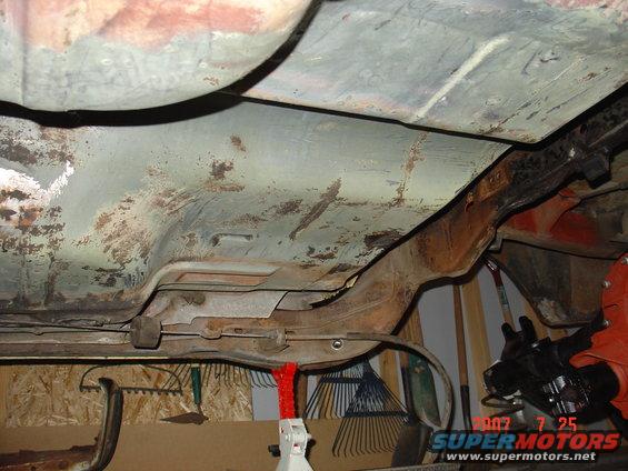 Undercarriage of a 1973 Ford Ranchero showing rusted floorboards and frame components