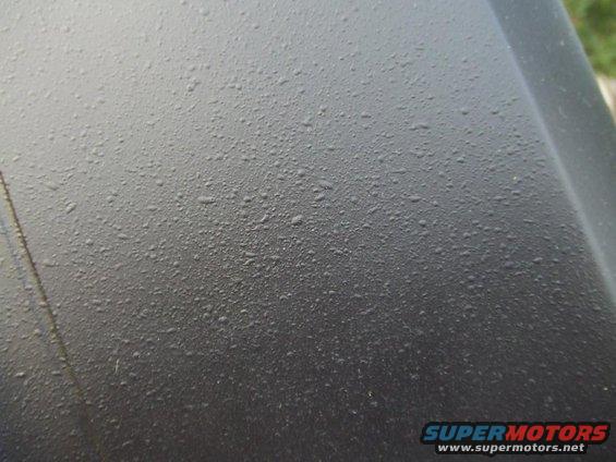close-up of water droplets on a dark car hood