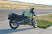 1998 BMW R1100GS ABS - A yellow 1998 BMW R1100GS ABS motorcycle with black saddlebags is parked on a sidewalk next to a road.