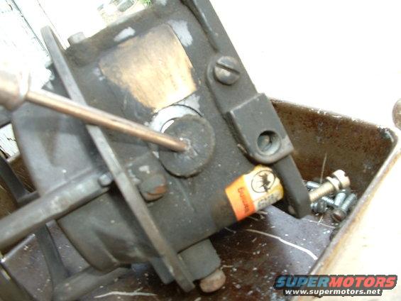 Carburetor with screwdriver, orange label with text
