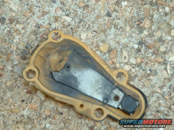 Yellow gasket with metal plate and black component on gravel