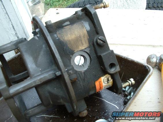 Carburetor with orange warning sticker and visible screws