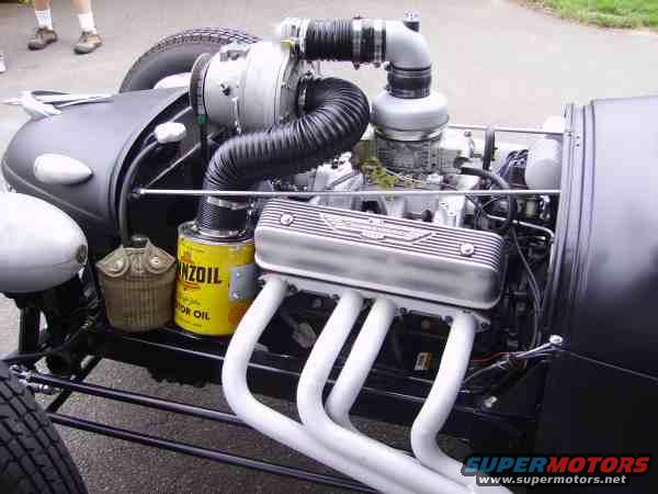 Engine with turbocharger, yellow oil can, and white exhaust headers