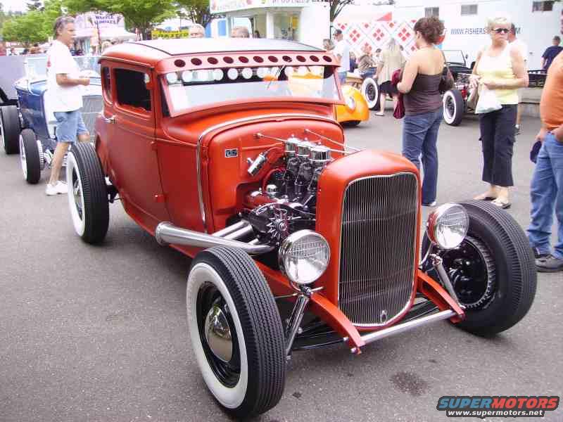 Red hot rod with exposed engine and whitewall tires