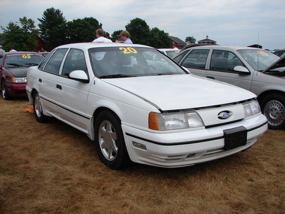 White 1993 Ford Taurus sedan, 3q-front view, hood open. Yellow number 20 on windshield