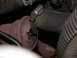 1987 Lincoln Town Car - A close-up view of a rusty exhaust pipe connection, held in place by a metal hose clamp on a dark rubber hose.
