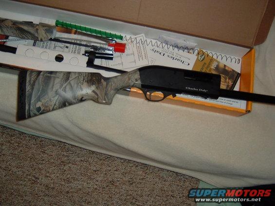 Shotgun with camouflage stock and black receiver labeled Charles Daly