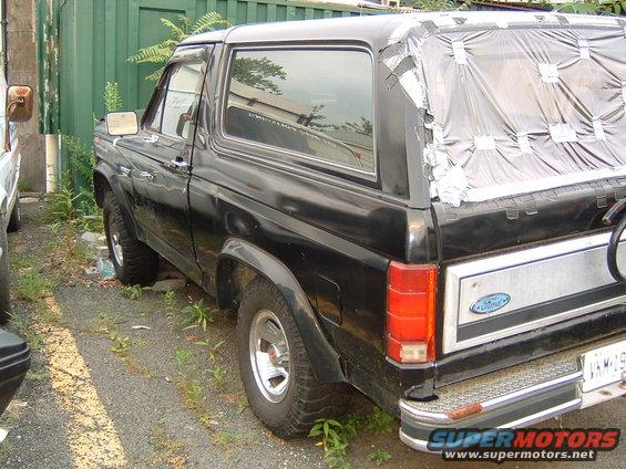 Black Ford Bronco with taped rear window, parked outdoors