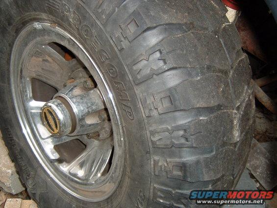 Close-up of a tire with 'PRO COMP' visible on the sidewall and a chrome wheel with a gold center cap