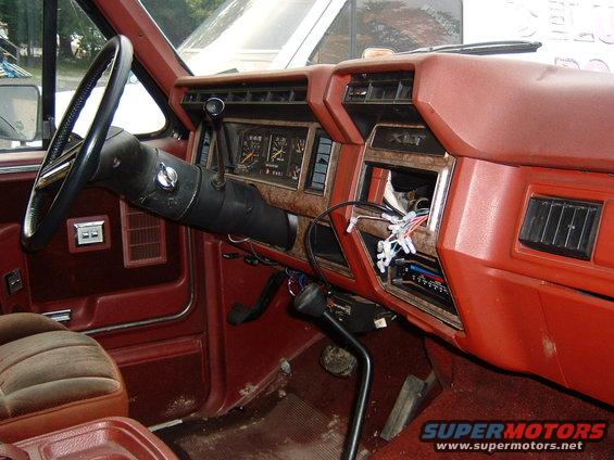 Interior shot of a truck's dashboard, showing the steering wheel, gauges, and center console with exposed wiring