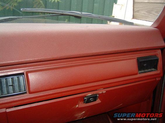 Red dashboard with glove box, air vents, and windshield wipers visible