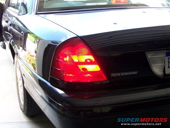Black 2003 Ford Crown Victoria Police Interceptor rear with illuminated taillights