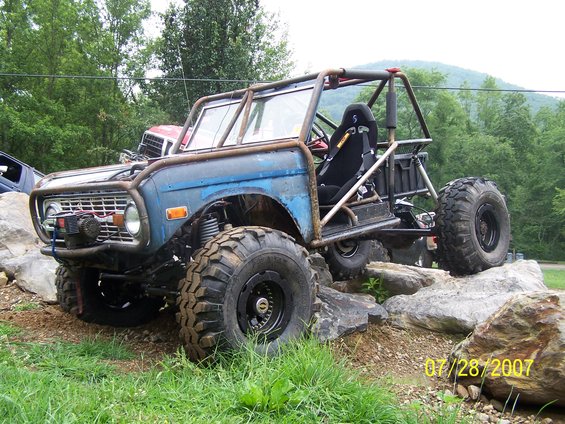 Blue off-road buggy with roll cage and big tires on rocks