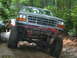 1992 Ford Mustang - This modified Ford truck navigates a rocky trail, its off-road capabilities and distinctive grille.
