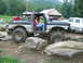 1992 Ford Mustang - Modified Ford Bronco tackling an off-road obstacle course with large tires.