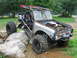 1992 Ford Mustang - This heavily modified vehicle, likely a custom buggy, is positioned on a rocky terrain, a prominent roll cage and a winch.